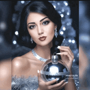 a woman is holding a christmas ornament in her hand