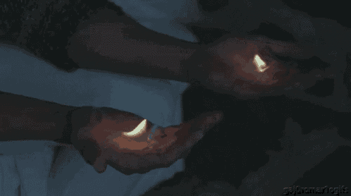 a person is holding two candles in their hands and the candles are lit up