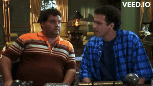 two men sitting next to each other with the words veed.io on the bottom right