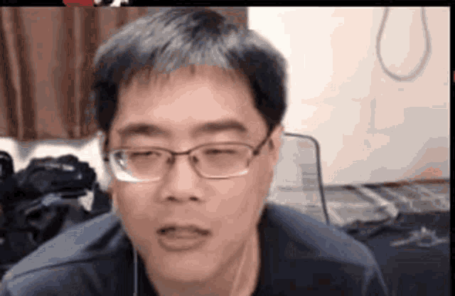 a close up of a man wearing glasses and ear buds .