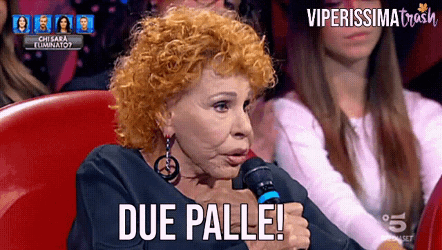 a woman holding a microphone says due palle