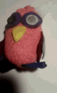 a pink stuffed animal with a yellow beak and sunglasses