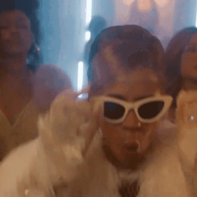 a man wearing sunglasses is making a funny face in a blurry photo