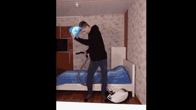 a man is using a vacuum cleaner to clean a bedroom
