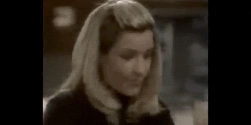 a woman is looking at the camera with a serious look on her face .