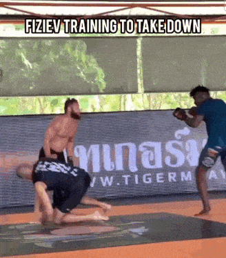 two men are fighting in a gym with the words " fiziev training to take down " at the top