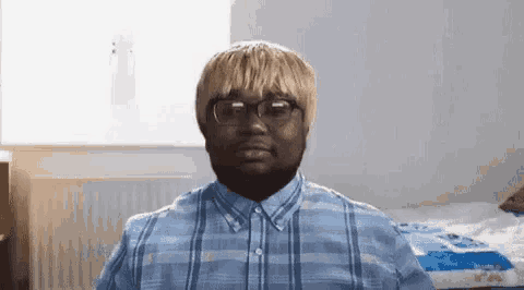 a man with blonde hair and glasses is wearing a plaid shirt and a wig .