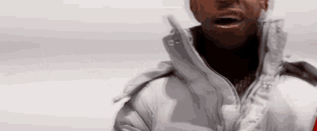 a close up of a man wearing a white jacket and a red hat .
