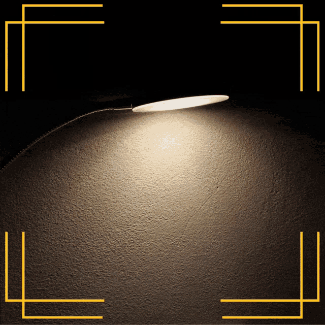 a light is shining on a wall with a yellow border around it