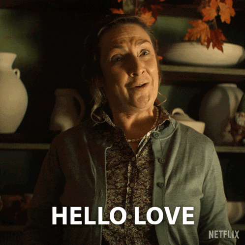 a woman says hello love in front of a shelf of vases