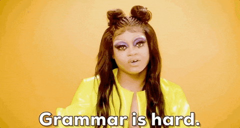 a drag queen is wearing a yellow jacket and says `` grammar is hard '' .