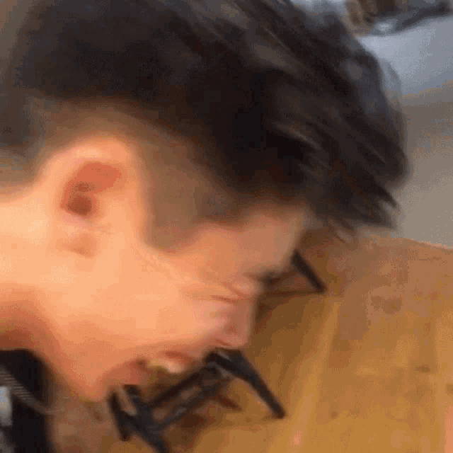 a close up of a man 's face with a chair in the background