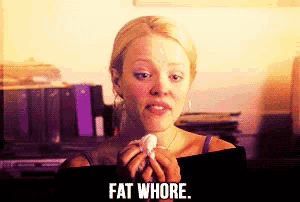 a woman holding a piece of paper with the words fat whore written on it
