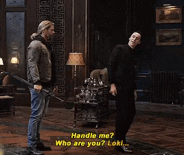 two men are standing next to each other in a room .