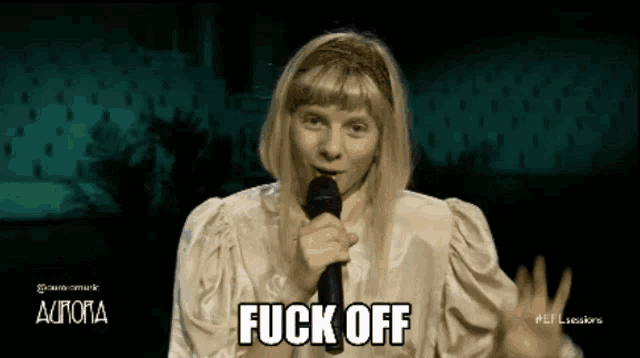 a woman singing into a microphone with the words " fuck off " above her