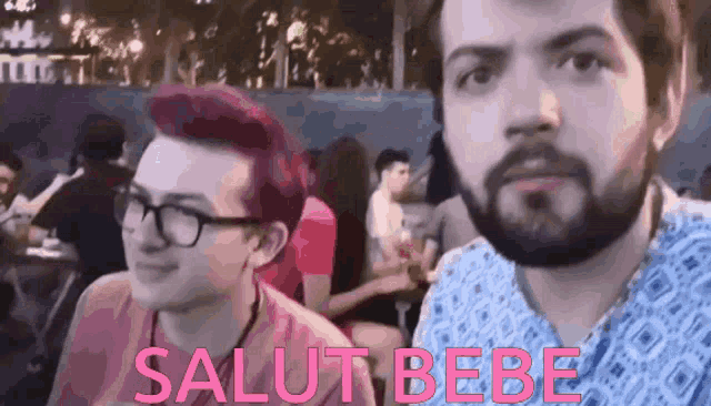 two men sitting next to each other with the words salut bebe written in pink