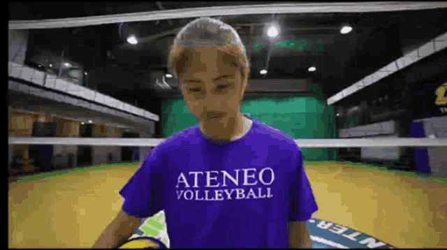 a woman wearing a purple shirt that says ateneo volleyball on it