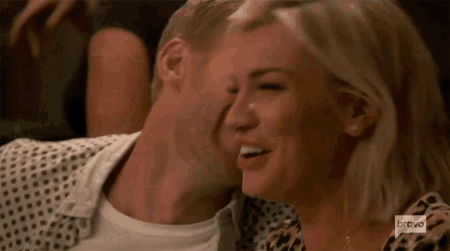 a man is kissing a woman on the cheek while on bravo