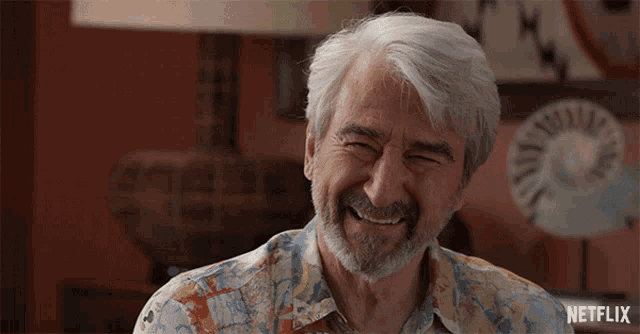 a man with gray hair and a beard is smiling with a netflix logo below him