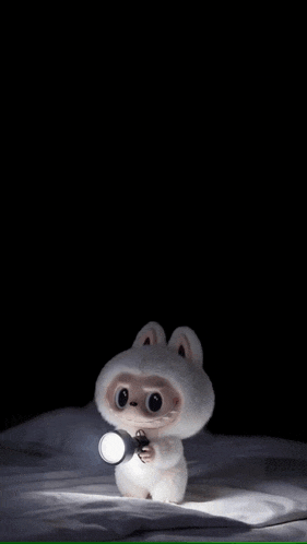 a stuffed animal is holding a flashlight in its hands