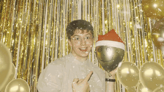 a man wearing a santa hat is holding a balloon