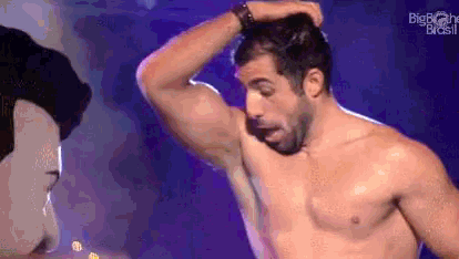 a shirtless man with a beard is standing on a stage .