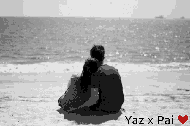 a black and white photo of a man and a woman sitting on the beach with yaz x pai written on the bottom