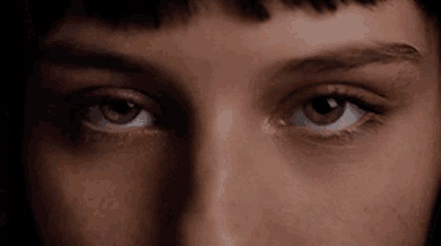 a close up of a woman 's eyes with a black background .