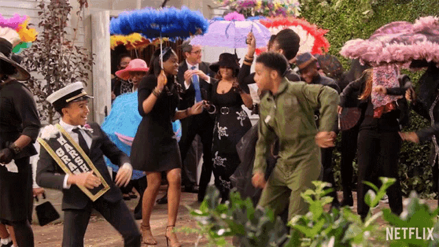 a group of people are dancing in front of a sign that says netflix on it