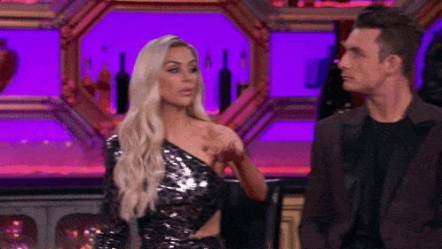 a woman in a sequined dress and a man in a suit are standing next to each other
