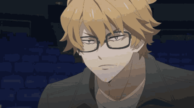 a man wearing glasses and a black jacket is looking at the camera
