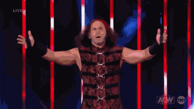 a man with his arms outstretched in front of a live aew advertisement