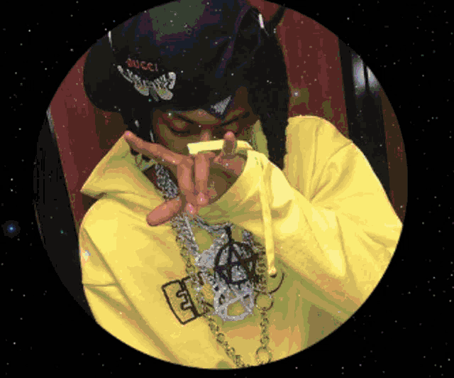 a person wearing a gucci hat and a yellow sweatshirt