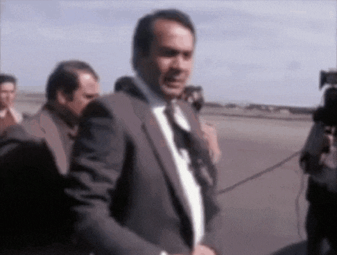 a man in a suit and tie is being interviewed by a cameraman