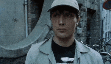 a man wearing a hat and a t-shirt that says " hitting "