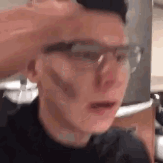 a man wearing glasses is being punched in the face by another man .