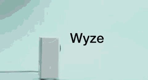 a white wyze cam pan is sitting on a green surface