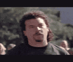 a man with a beard is standing in front of a crowd of people .