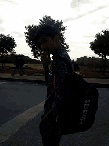 a man carrying a black adidas duffel bag