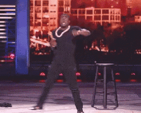 a man is dancing on a stage with a stool in front of him