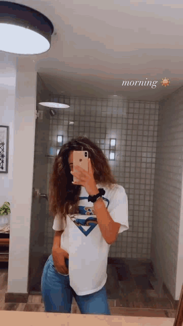 a woman is taking a selfie in front of a mirror with the word morning above her head