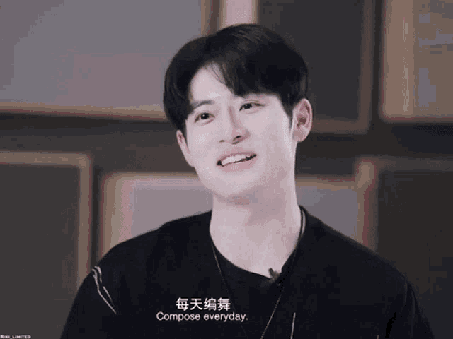 a young man wearing a black shirt and a necklace says compose everyday