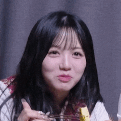 a close up of a woman eating a piece of food with a fork