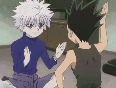 a couple of anime characters are giving each other a high five while sitting on the floor .