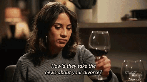 a woman is holding a glass of wine and talking about her divorce .