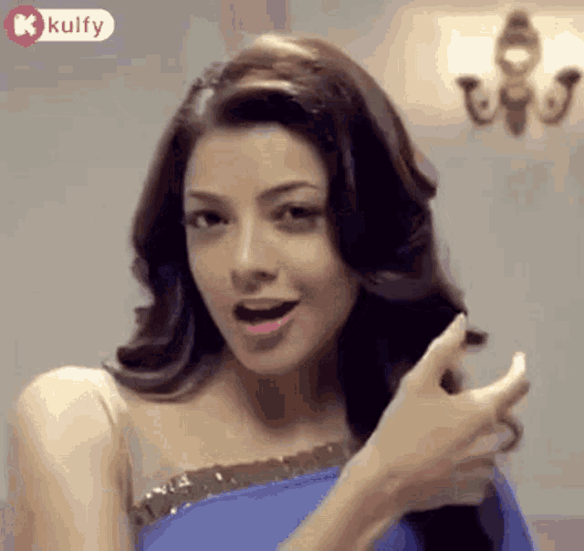 a woman in a blue dress is giving a thumbs up