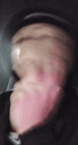 a blurry picture of a person 's face with a pink tongue sticking out
