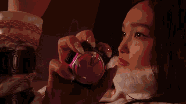 a woman is holding a purple object in her hands