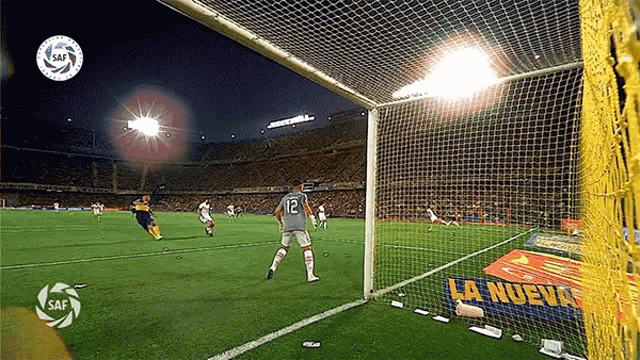 a soccer player with the number 12 on his jersey kicks the ball
