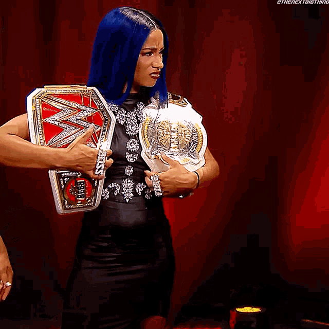 a woman in a black dress is holding a wwe championship belt
